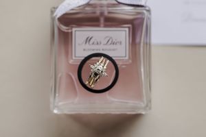 Fragrance bottles with pink liquid displayed in a row showing different angles and reflections in soft lighting.