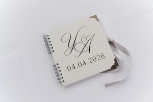 Custom wedding guest book with elegant script initials Y and A and date 04.04.2026 on white cover.