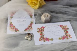 Delicate floral wedding invitations with pink flowers and gold ring box on tulle fabric.