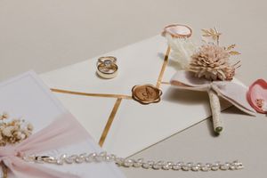 Jewelry making supplies and tools including chains, pliers, beads and ribbons arranged on a white surface.