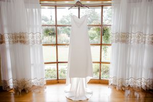 White sheer curtains with lace detailing hang elegantly on windows in a bright sunlit room.