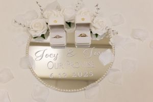 White and beige wedding champagne flutes with personalized tags and ribbon decorations displayed on light background.