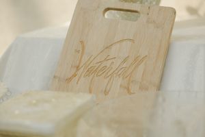 Handwritten names on a light tan colored wooden surface with elegant calligraphy style lettering.