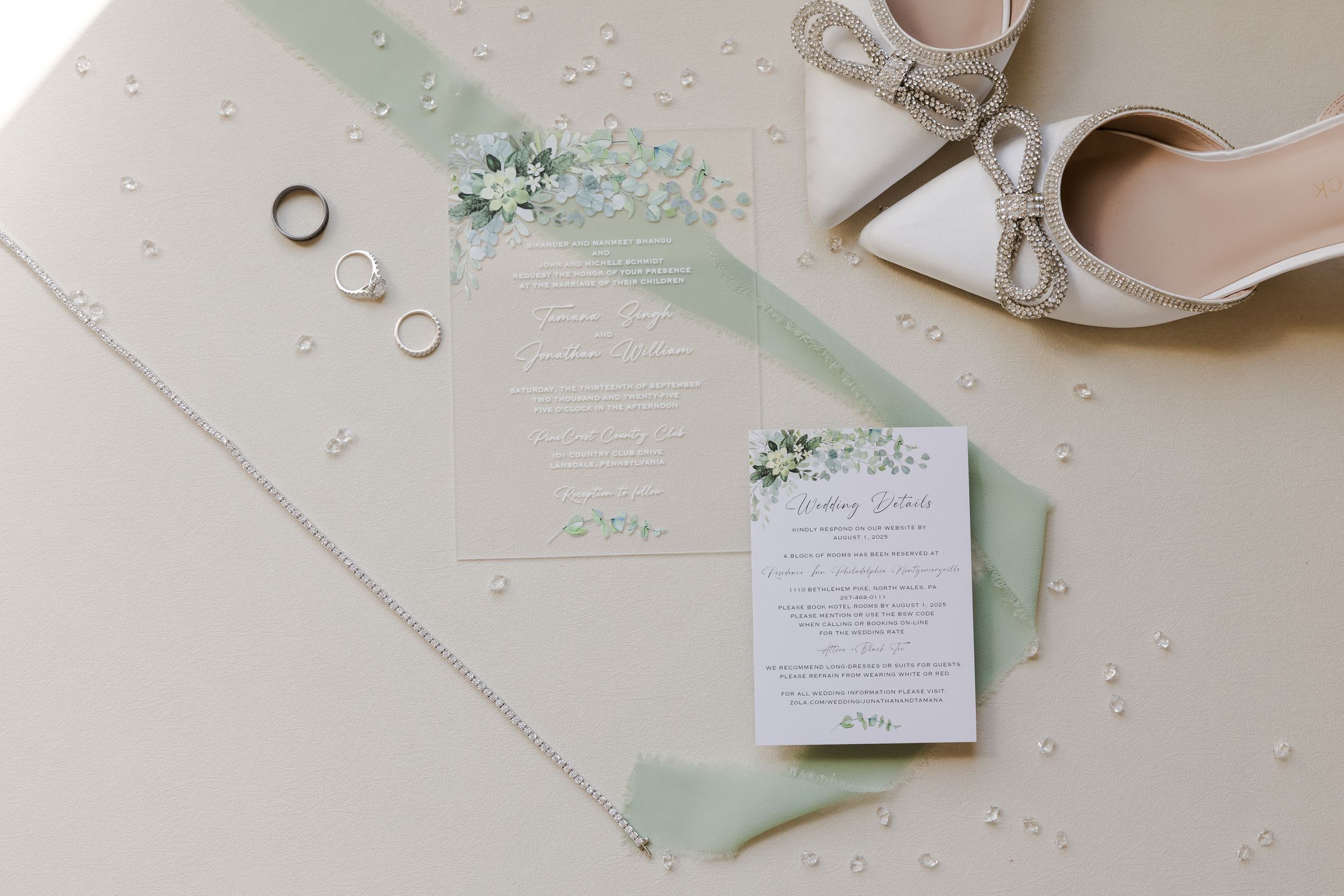 Soft mint green wedding invitations with elegant calligraphy and matching envelopes on a white textured surface.