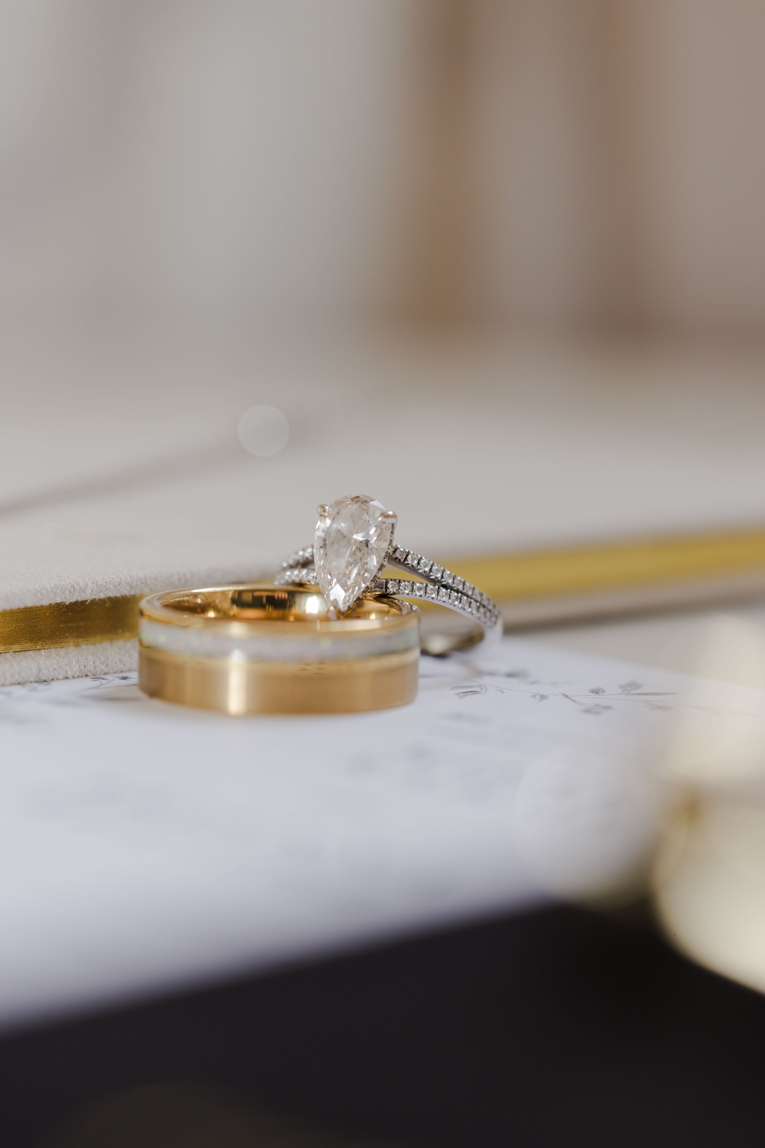 Close-up view of elegant gold wedding rings with diamonds resting on a white surface.