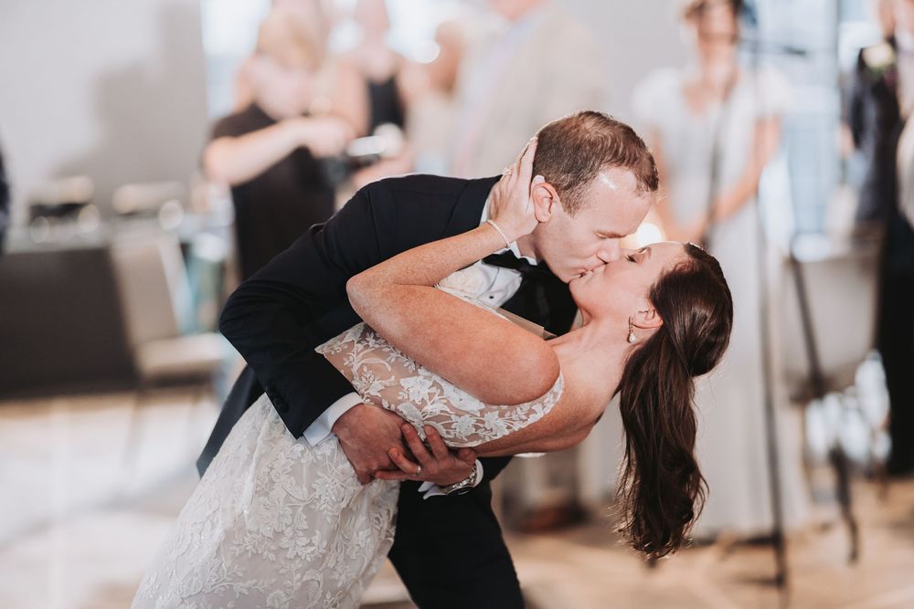 A couple performs a romantic dip while dancing at their wedding reception.