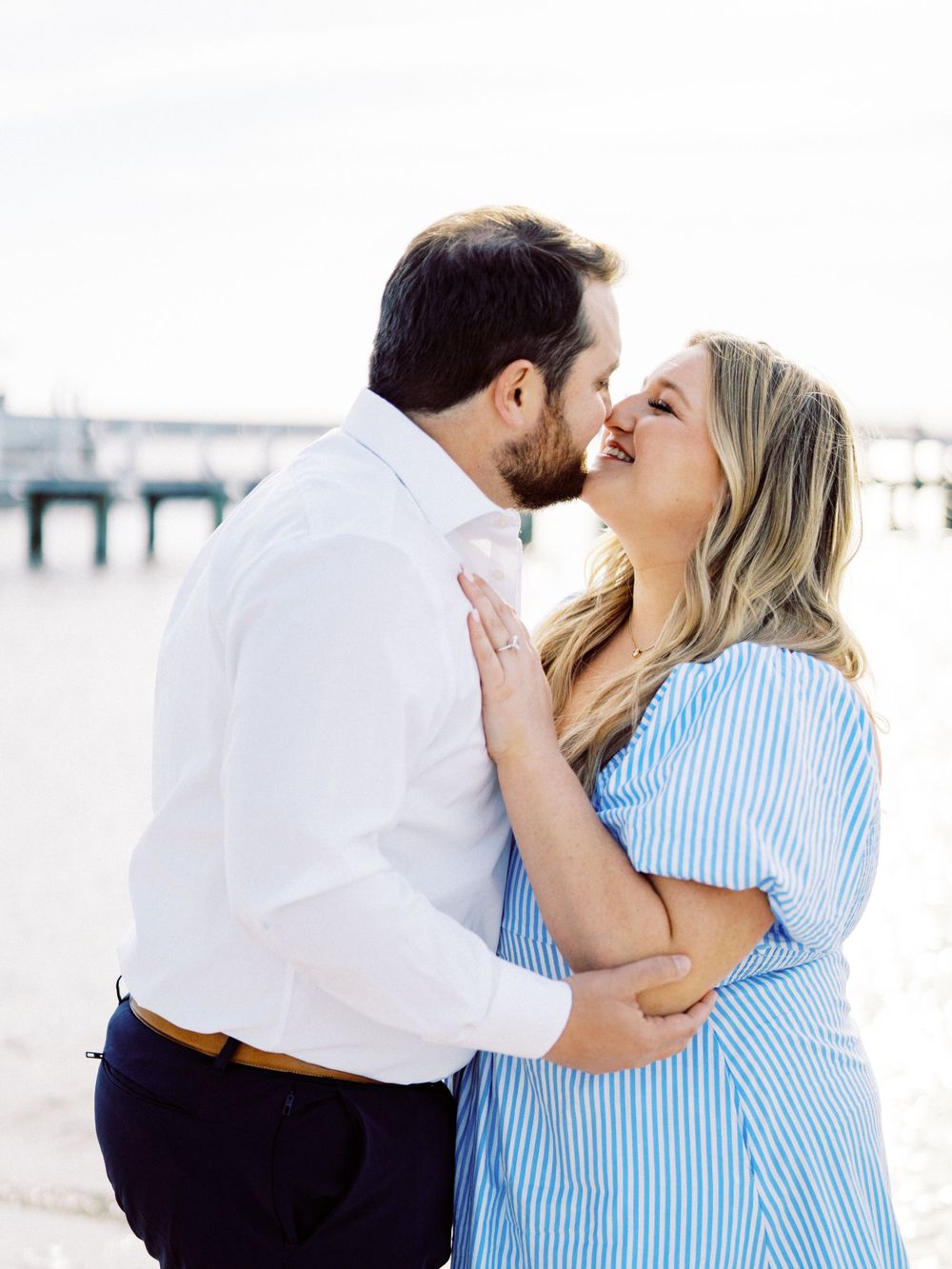 Romantic moment captured between a couple embracing on a sunny beach.