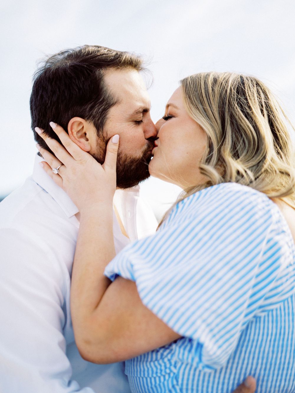 Intimate moment shared between a couple kissing by the ocean.