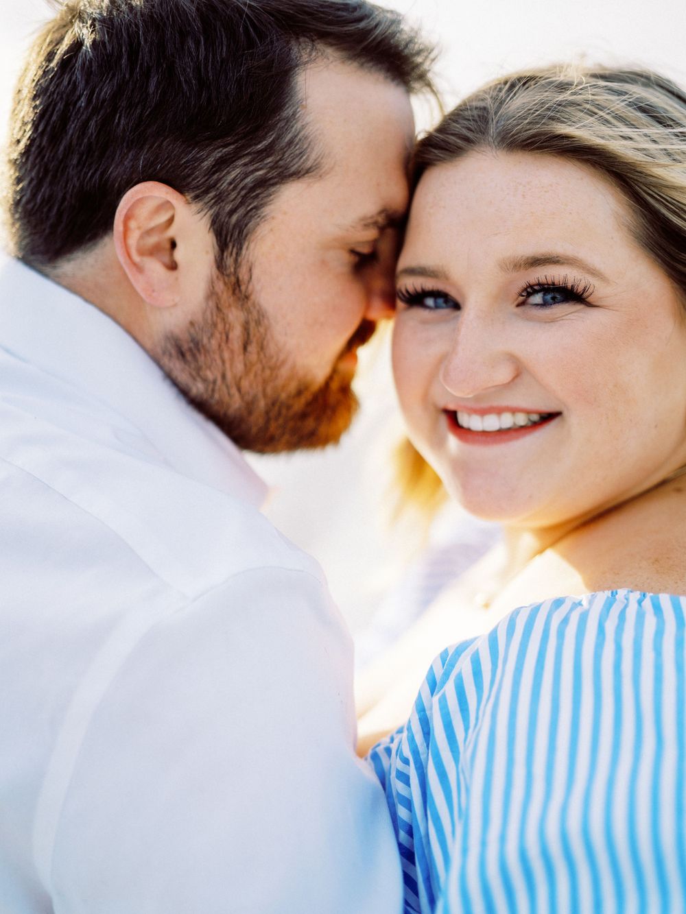 Close up of a tender moment between two people in blue and white attire.