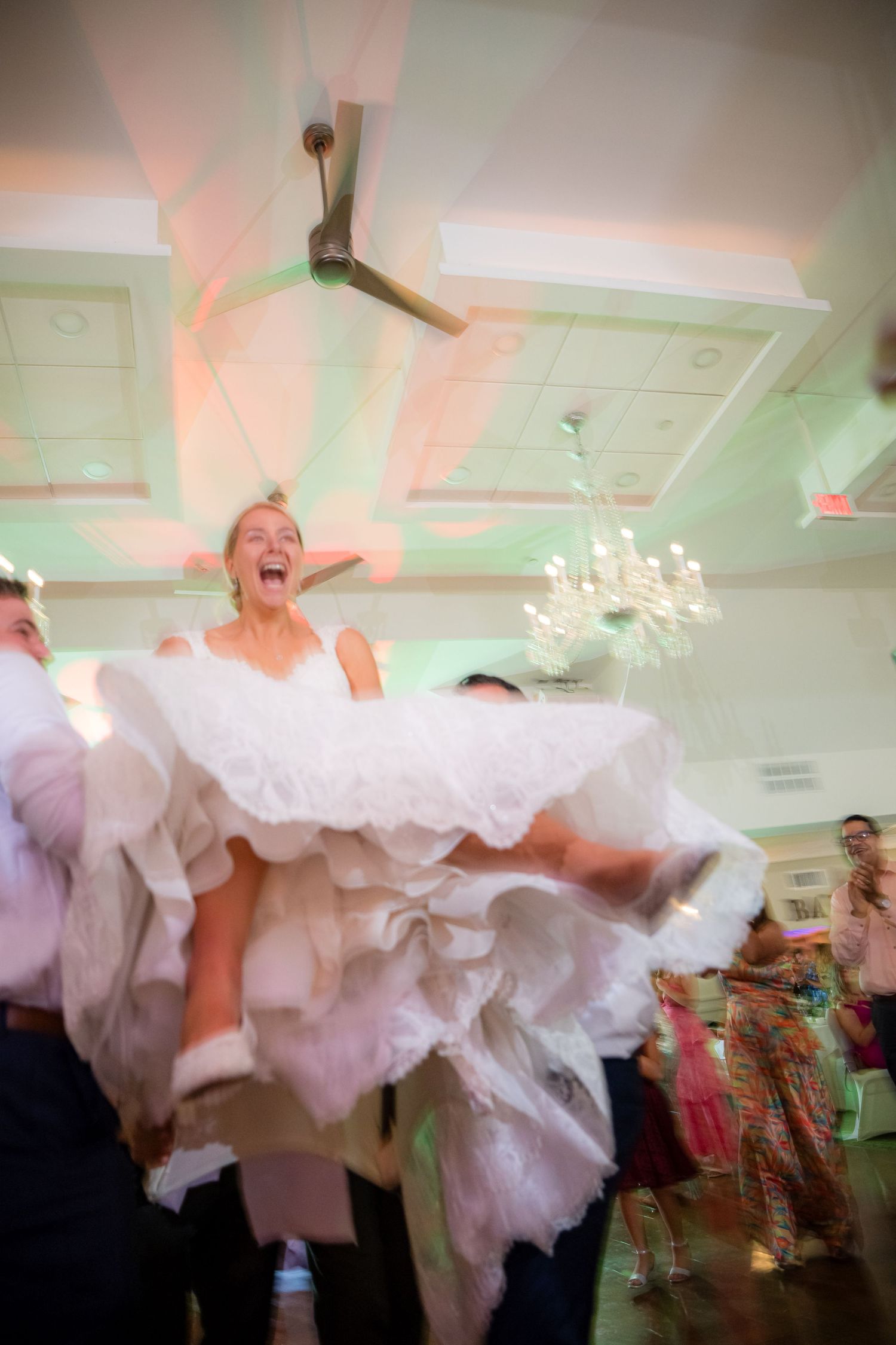 BRIDE IN THE AIR AS THE PARTY IS RAMPING UP.
