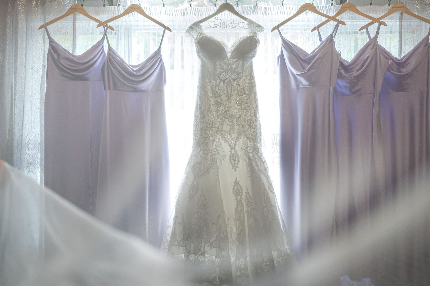 WEDDING AND BRIDE MAIDS DRESSES SHOT THROUGH VEIL IN AN ARTISTIC MANNER.