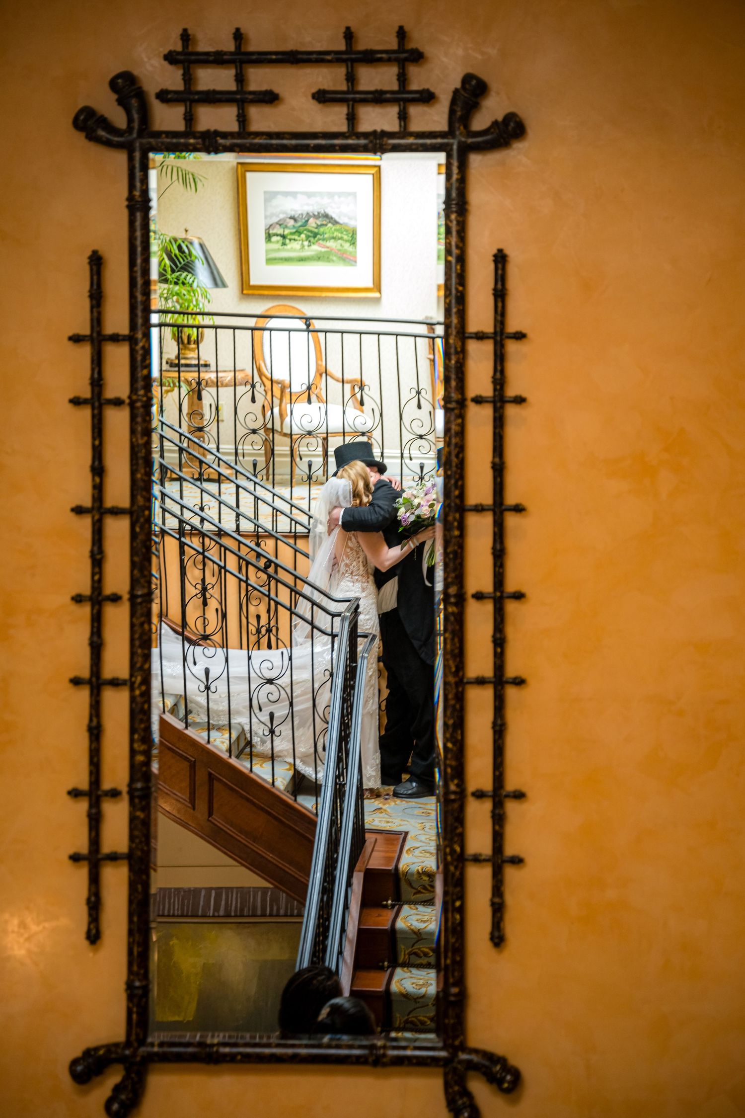 A series of five identical decorative black metal frames mounted on an orange wall in a hallway.