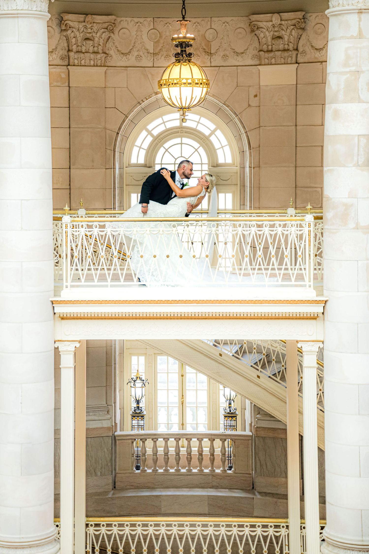 A CANDID MOMENT AT THE HARTFORD CITY HALL WEDDING PORTRAIT OF A THE GROOM DIPPING THE BRIDE WITH SMILES ON THEIR FACES