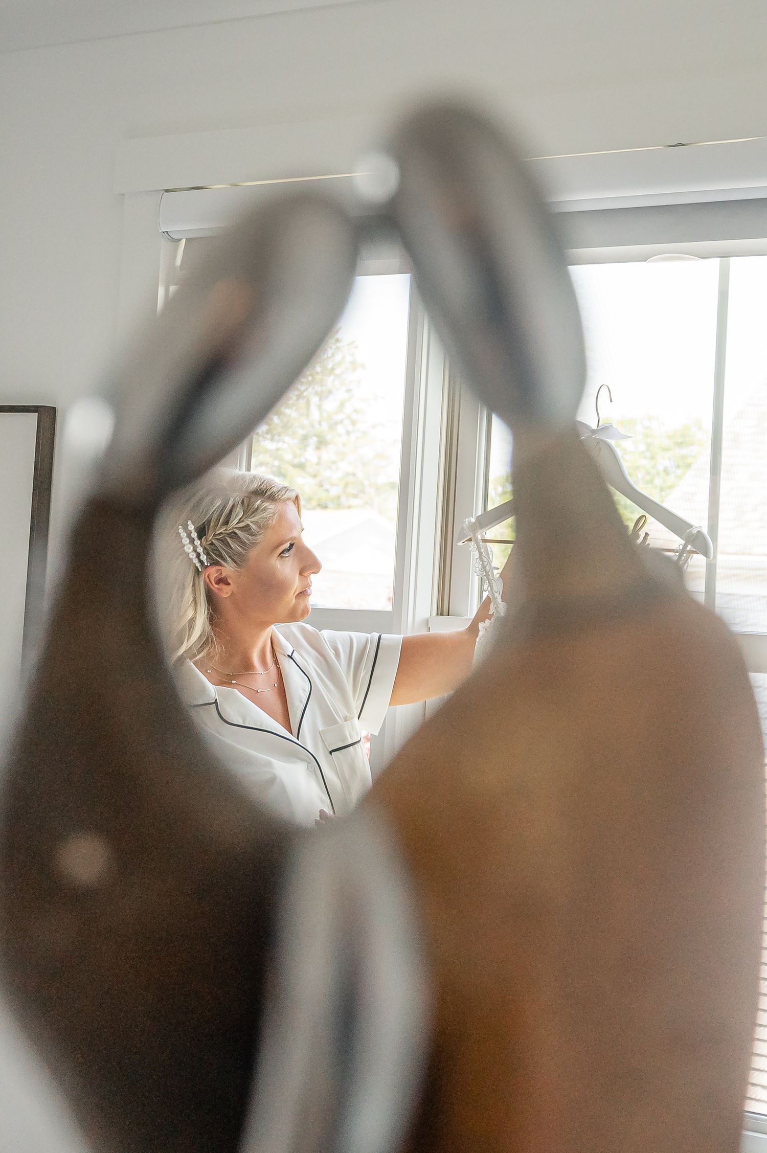Soft focus view through white tulle at someone in white pajamas standing by a bright window.