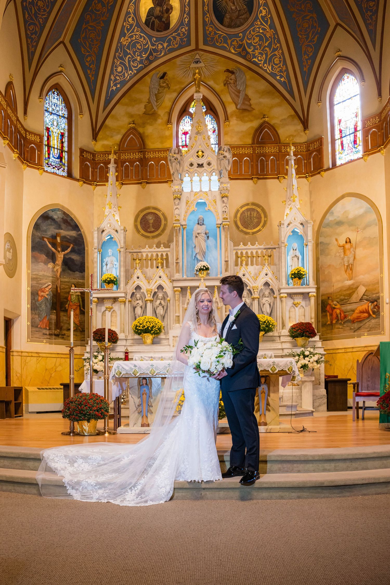 A panoramic view of a beautiful Catholic church interior with ornate architecture, stained glass windows and decorated altar.