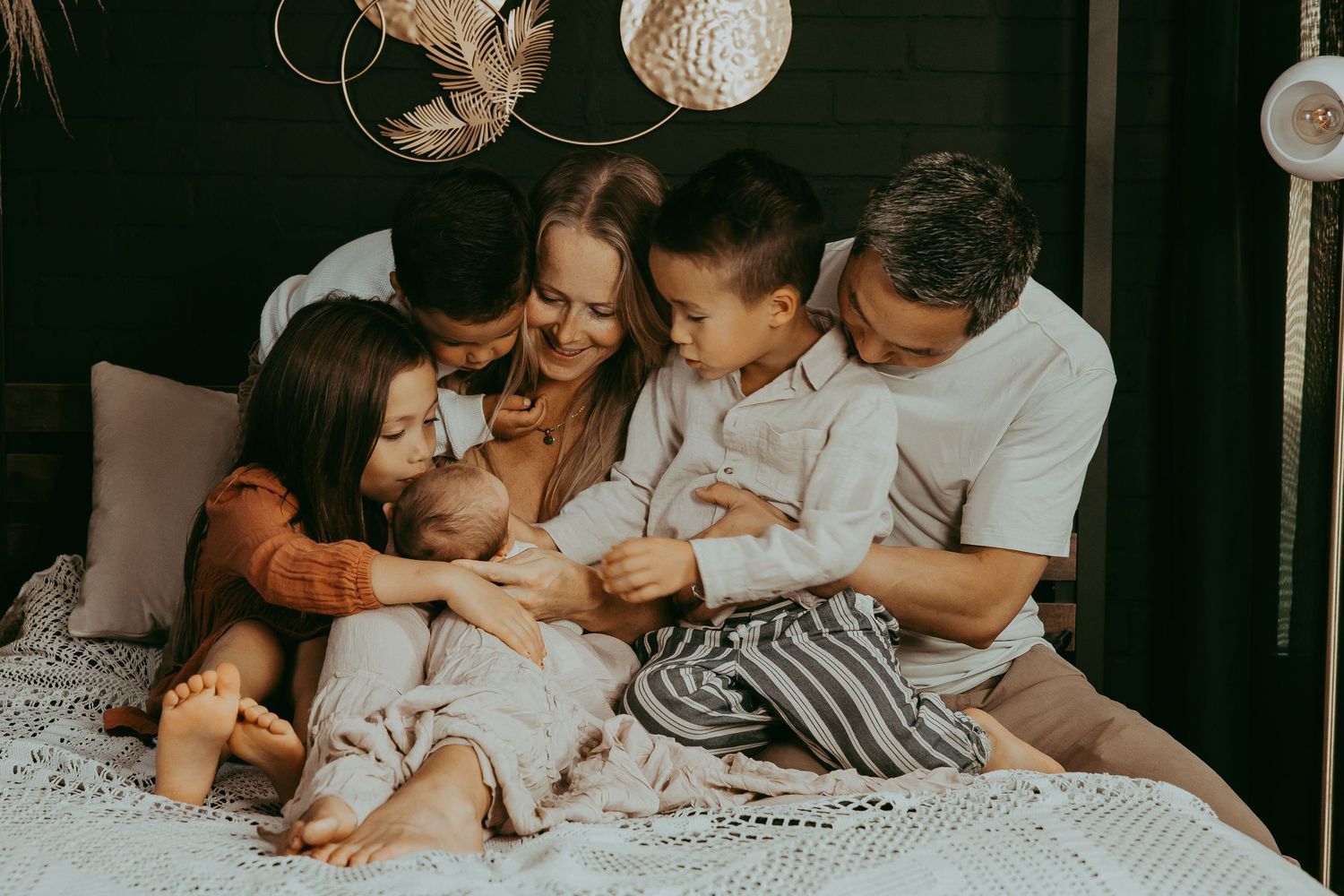 A family shares a tender moment together on a couch, creating an intimate and joyful portrait.