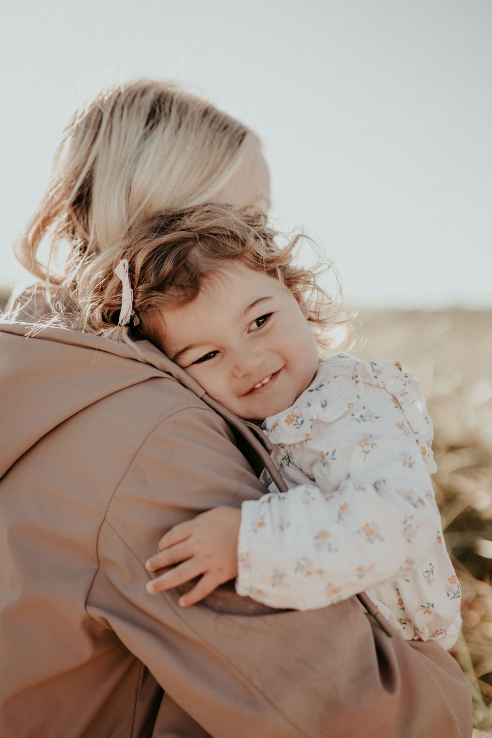 A heartwarming series of photos showing a tender embrace between parent and child in warm sunlight.