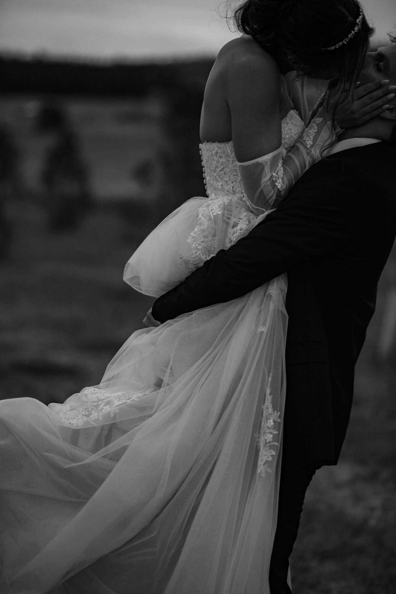 A black and white wedding ceremony emotional moment against a textured backdrop with the couple and officiant.