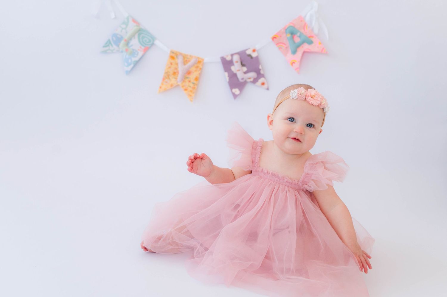 Bloomington, Illinois baby girl in a pink dress during her one-year sitter session by Julie Loy Photography