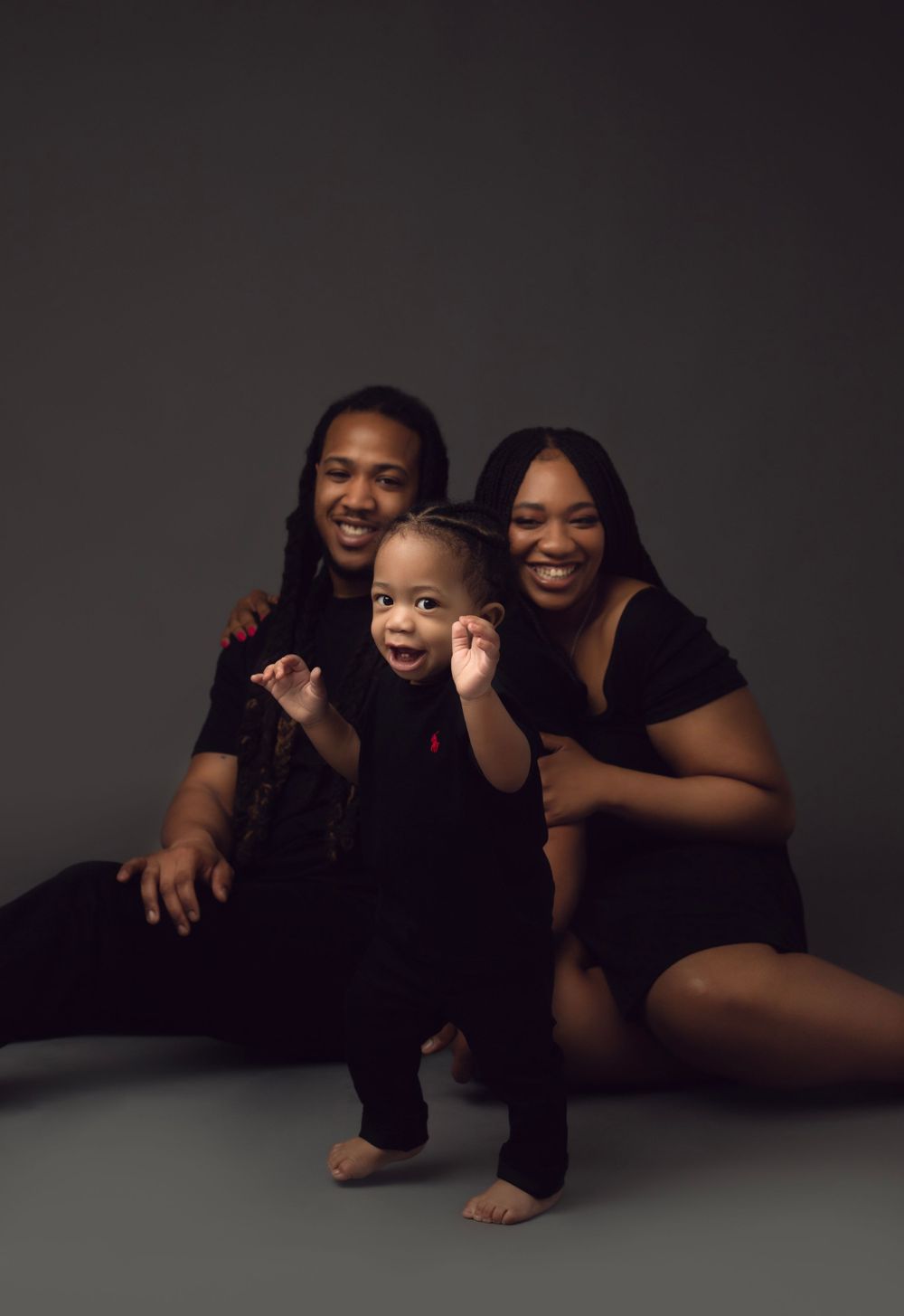 A photo of artistic black and white studio portraits showing intimate family poses against a dark background.