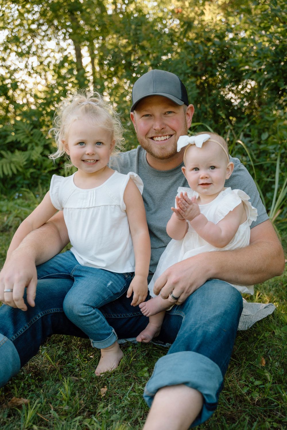 Casual outdoor family photos taken in a lush green setting during golden hour.