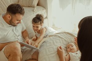 Family sharing intimate moments together on a cozy bed.