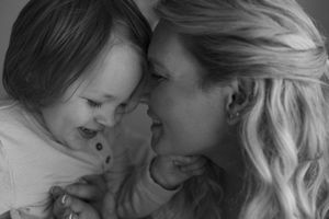 A tender black and white portrait of a parent and child sharing an intimate moment together.