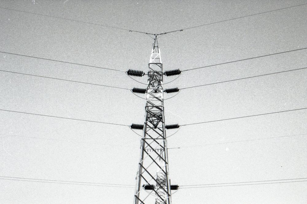 A series of black and white photographs showing electrical power transmission towers against a plain background.