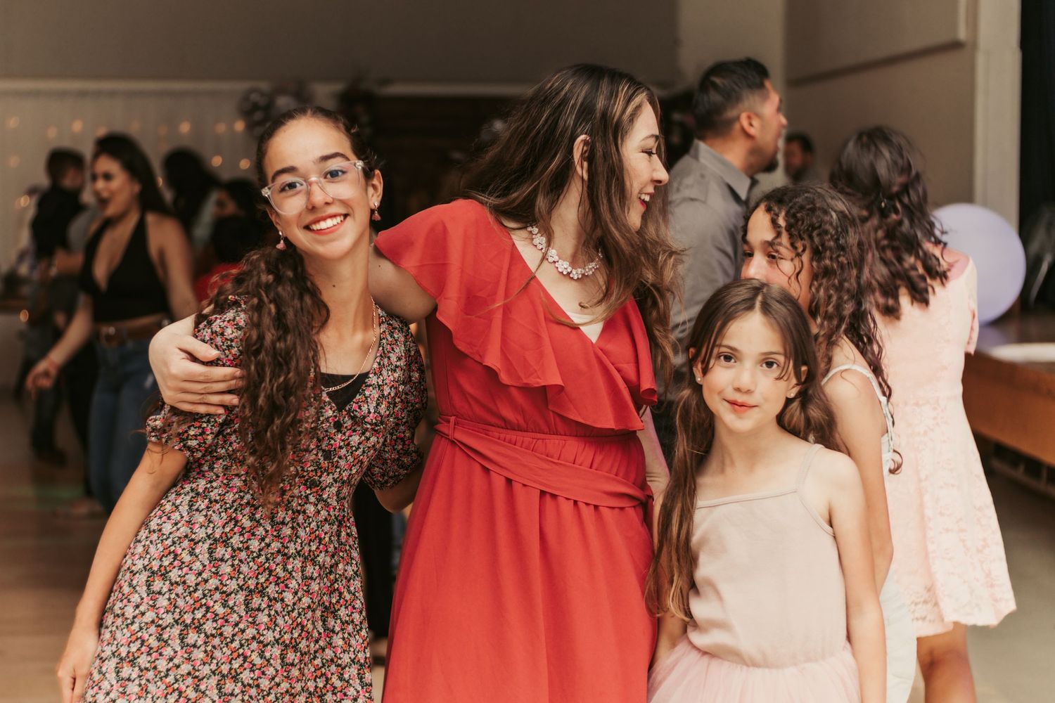 Celebratory gathering with people in colorful dresses sharing happy moments.