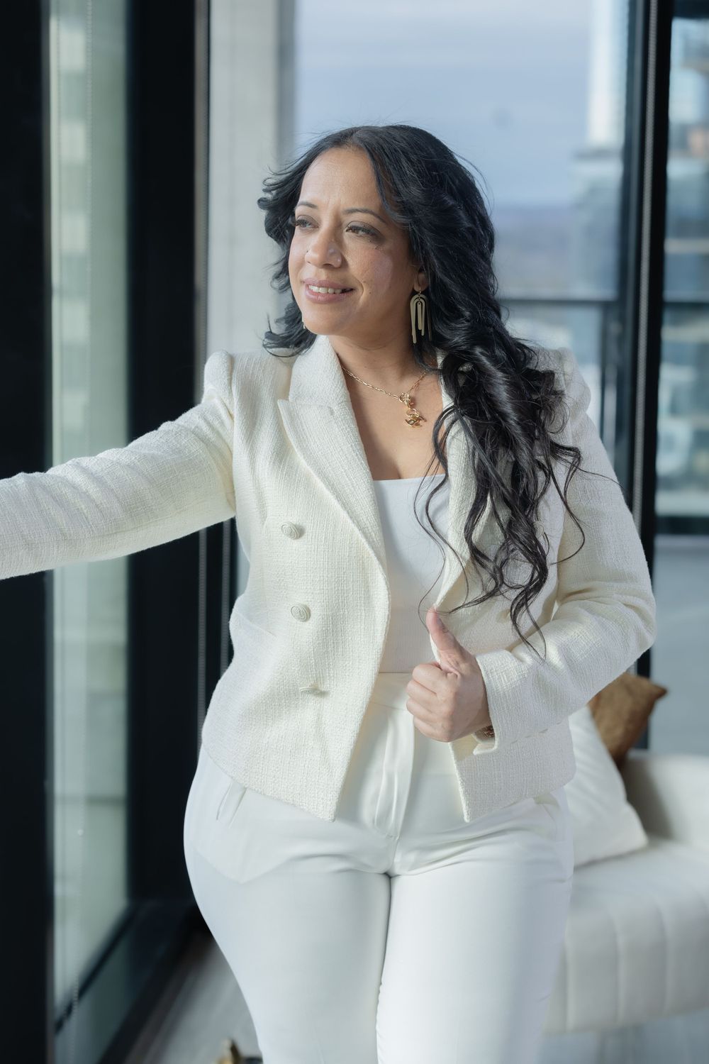 Dynamic business portraits in white outfit against modern window backdrop.