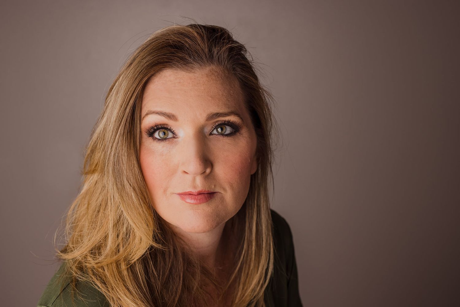 Professional headshot series showing different expressions and angles against neutral background.
