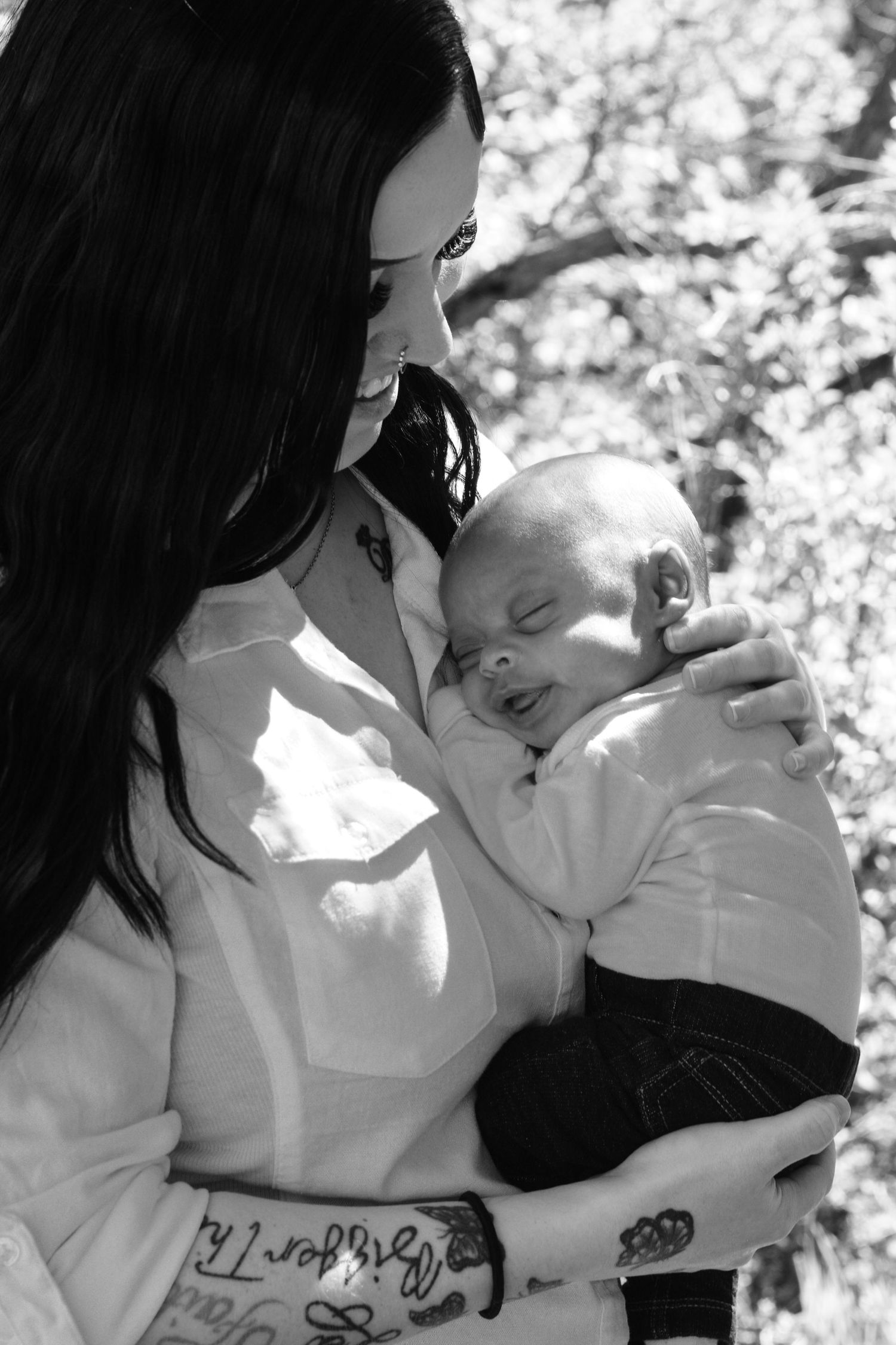 A tender black and white portrait of a parent and baby sharing a moment.