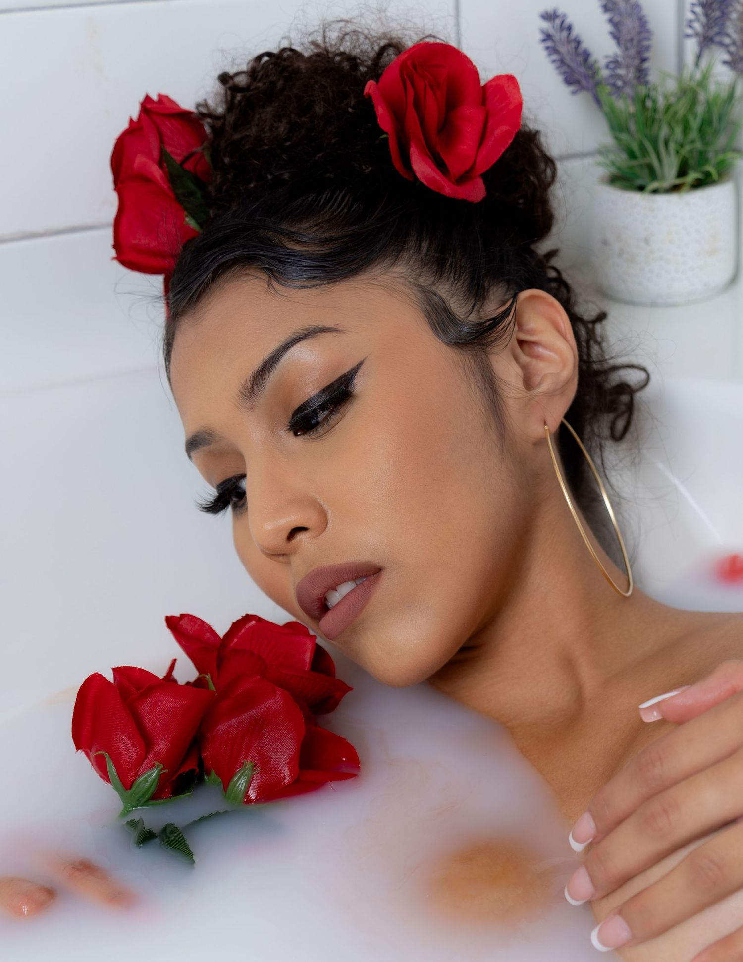 Artistic beauty portrait with red roses and dramatic makeup.
