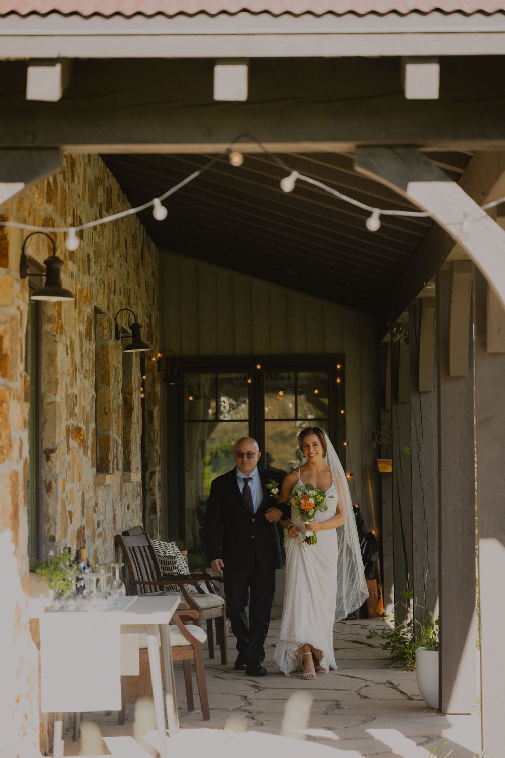 Couple holding hands walking down a gravel path at the ranch