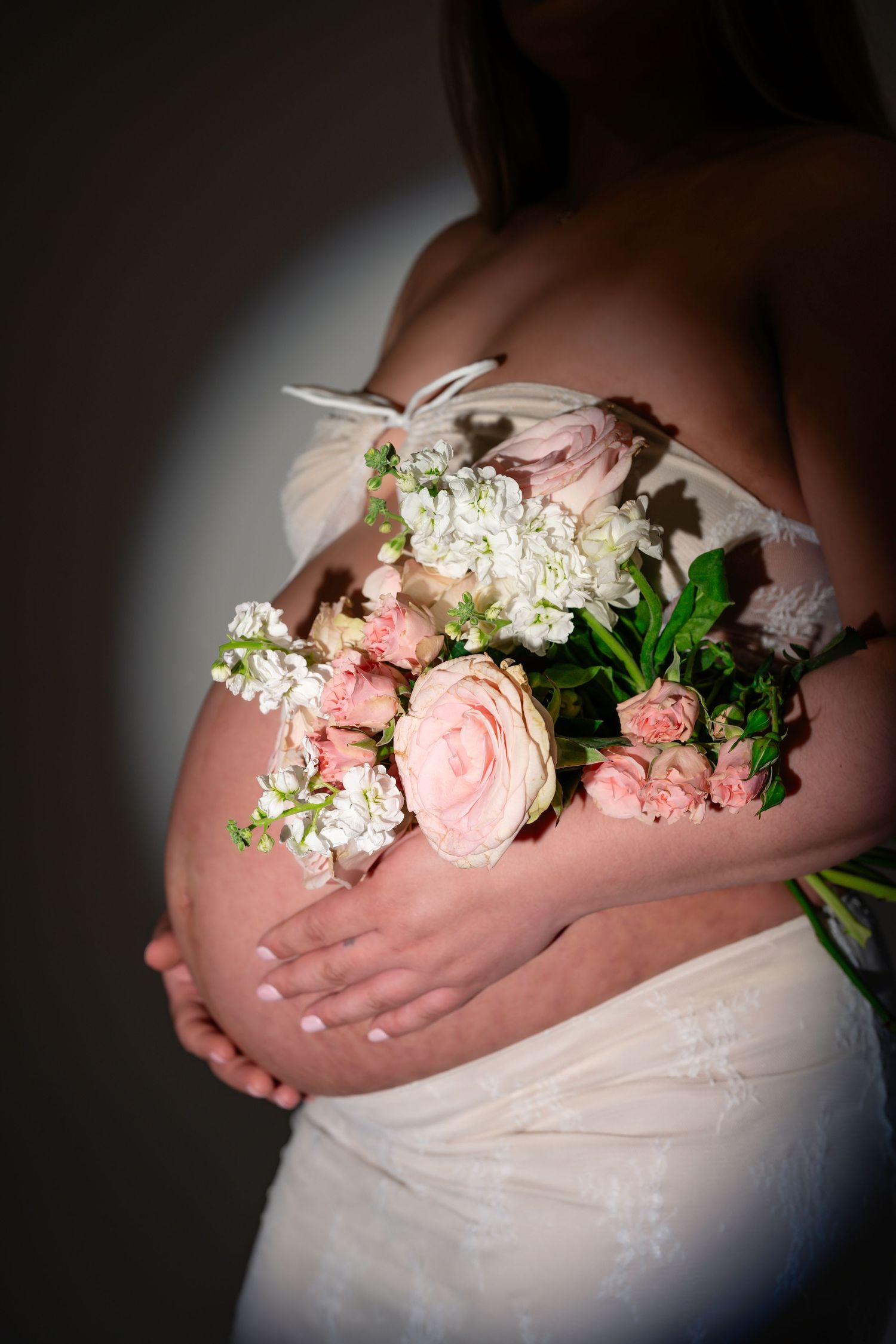 Delicate floral arrangement with pink roses and white flowers in soft lighting.