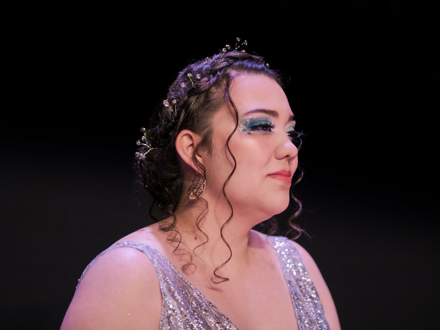 Close-up portrait showing detailed hair accessories and evening makeup.