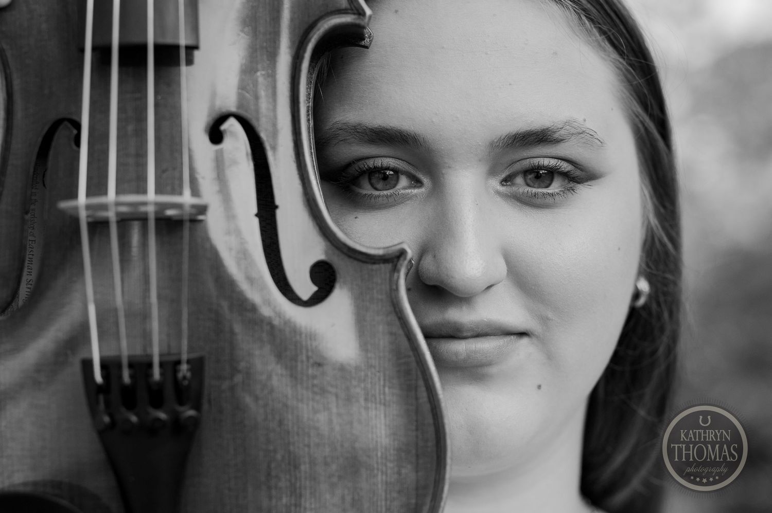 Artistic black and white closeup of violin with performer in soft focus.