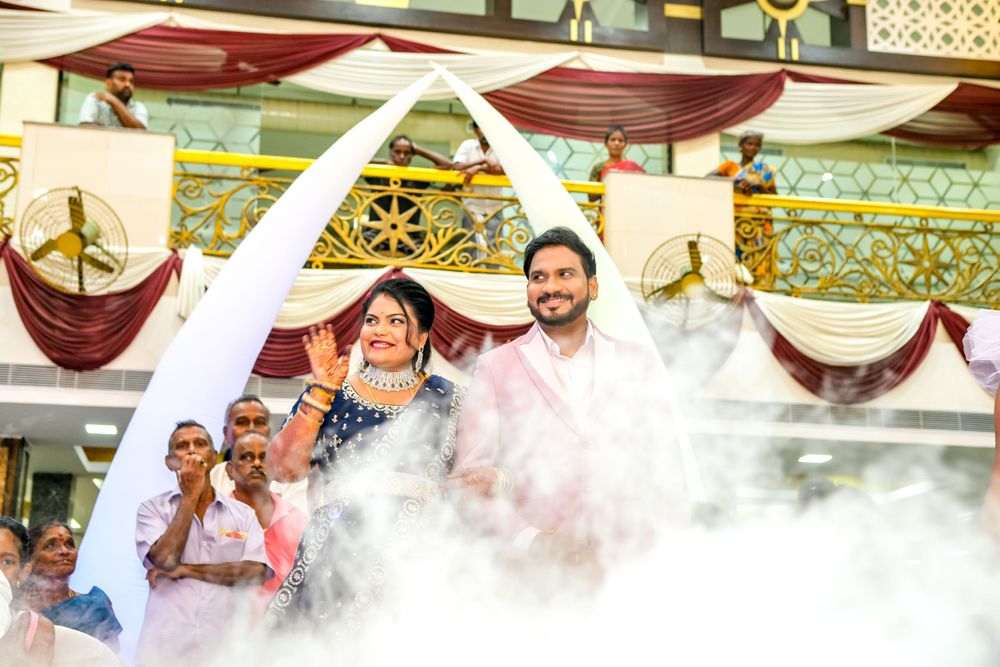 Couple celebrating during wedding ceremony with dramatic fog effects and white draping decorations.