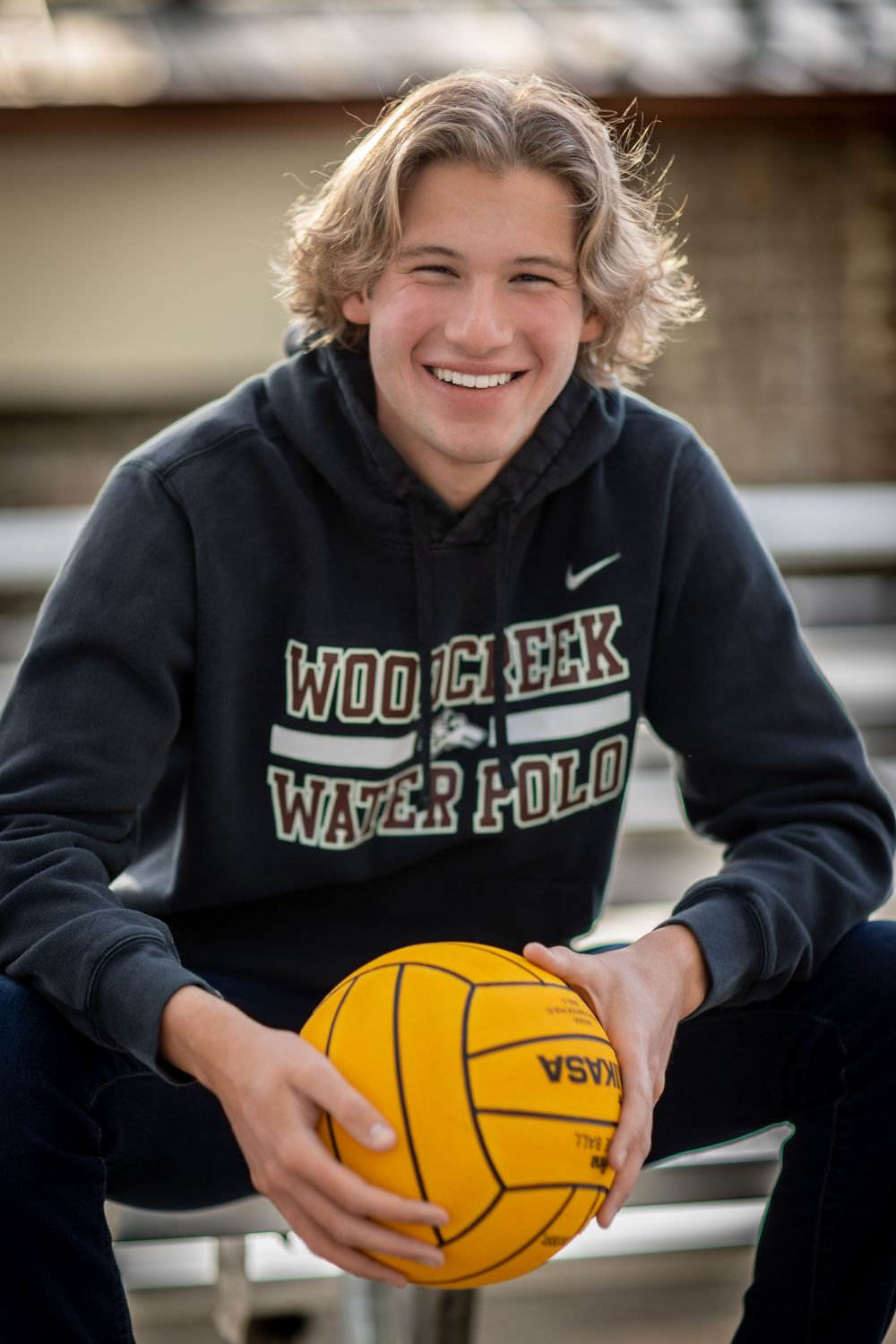 A series of photos showing a water polo player in a dark hoodie posing with a yellow water polo ball outdoors.