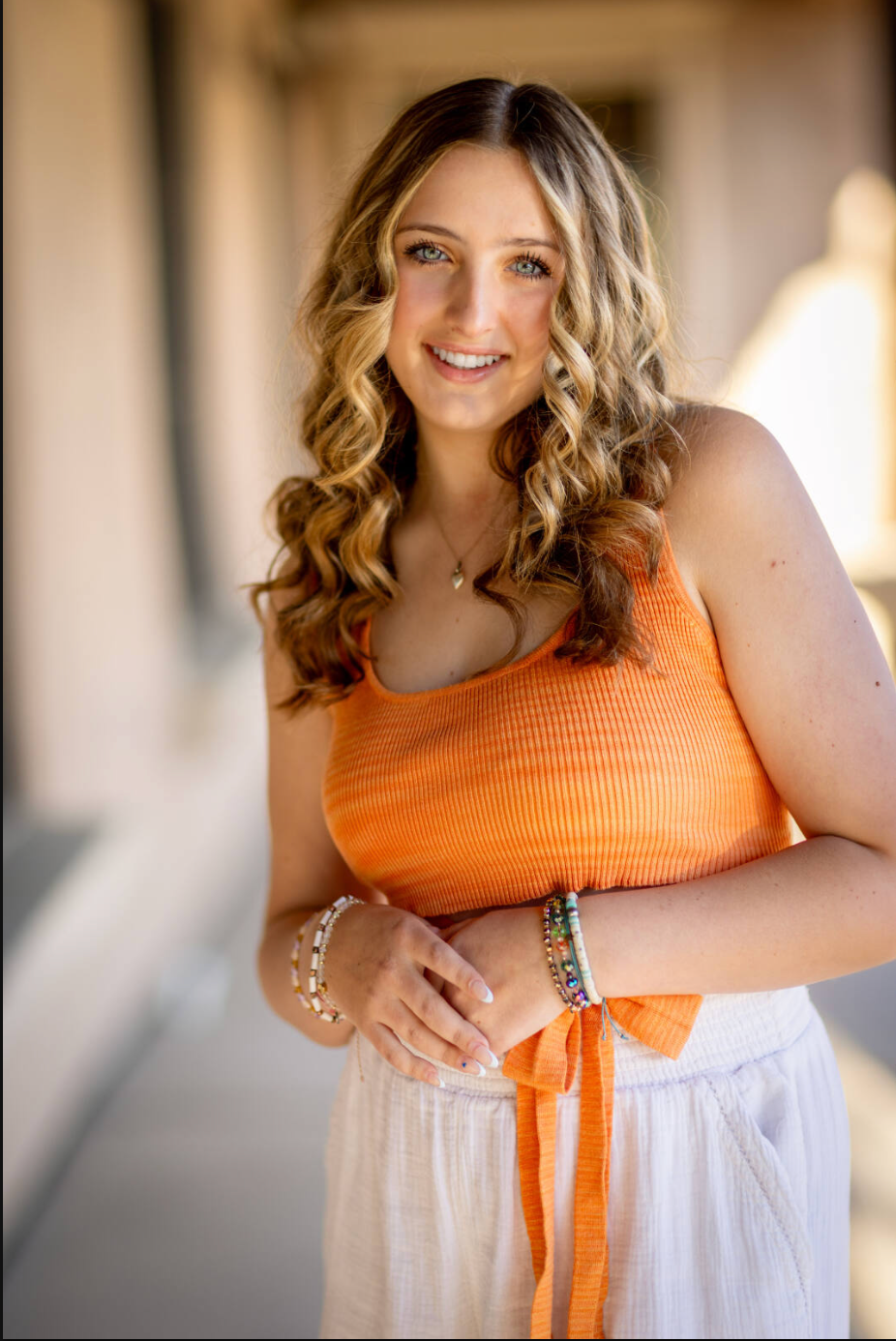A series of portraits showing a woman in an orange and white summer dress posing against a bright indoor background.