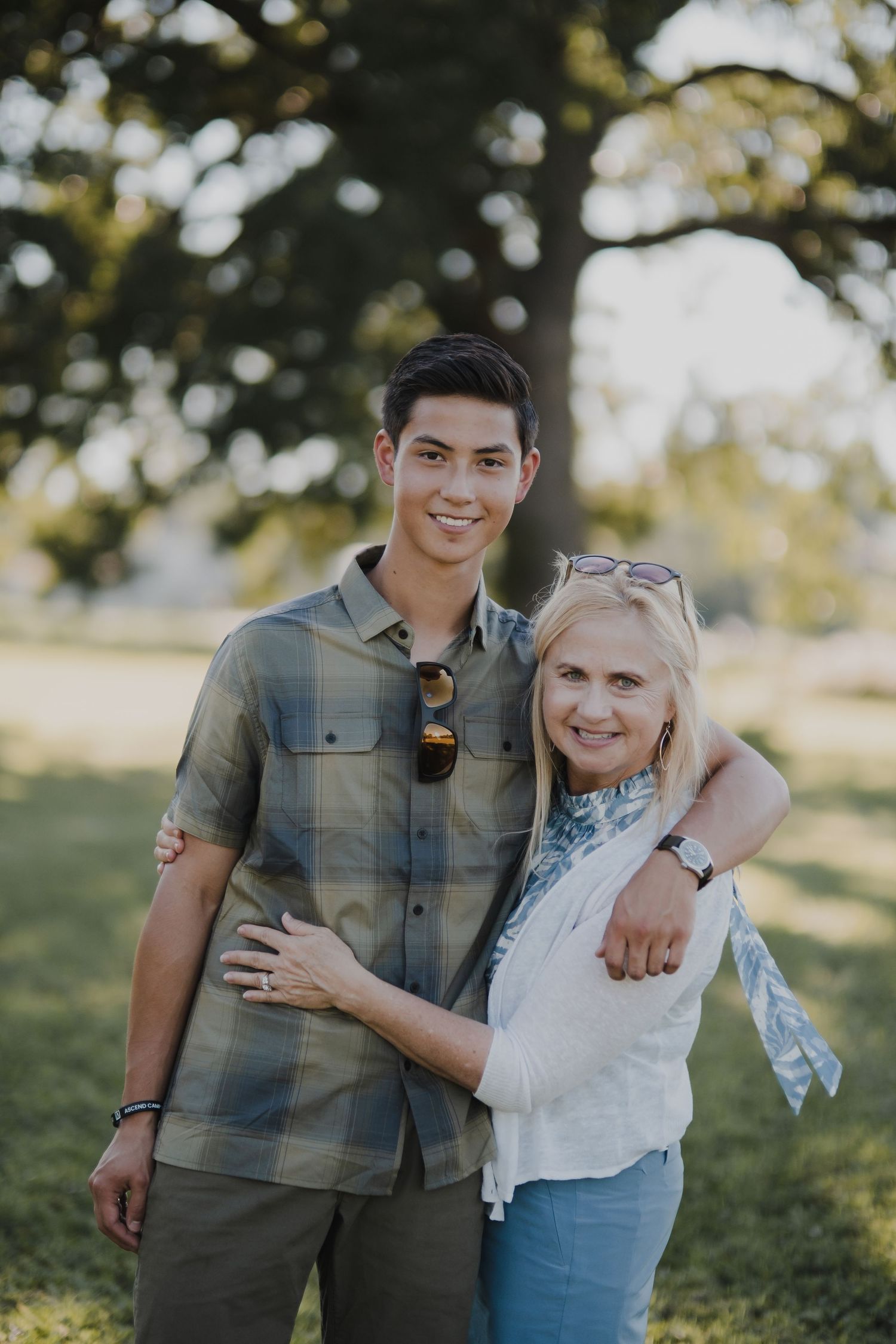 Couple sharing a tender moment outdoors in a sunny park setting.