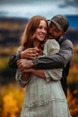 Couple embraces and laughs together during fall engagement photoshoot.