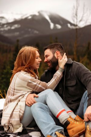 Joyful moment captured between couple laughing together in mountain setting.