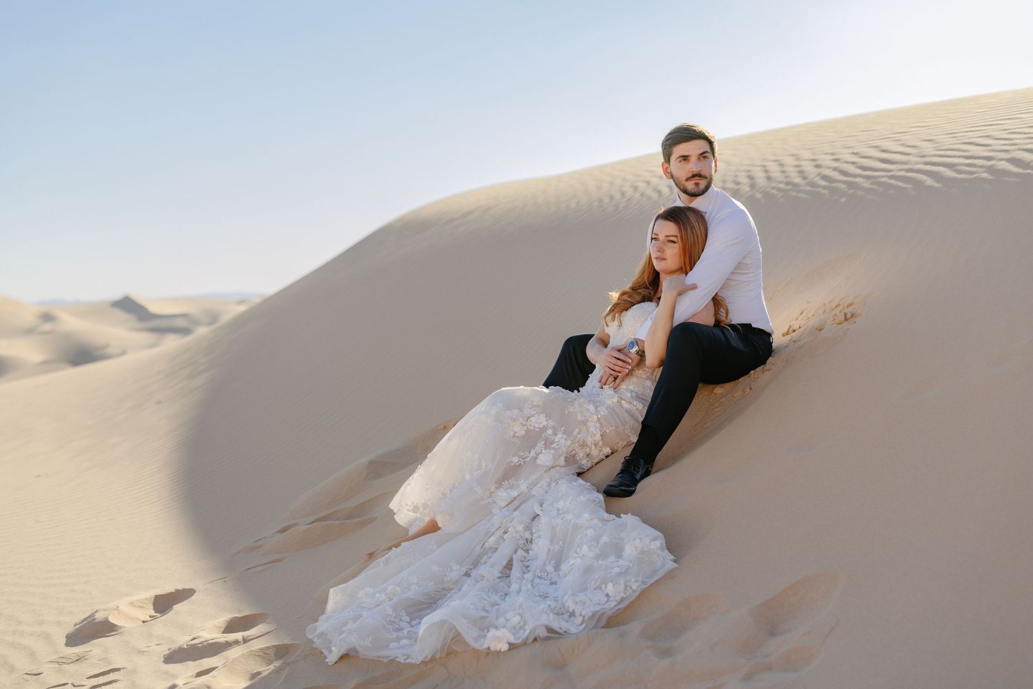The couple shares a romantic kiss, surrounded by wedding guests.