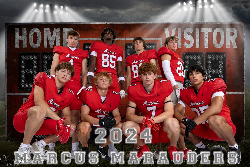 High school football players in red jerseys pose together on bleachers in front of a scoreboard for 2024 Marcus Marauders team photo.