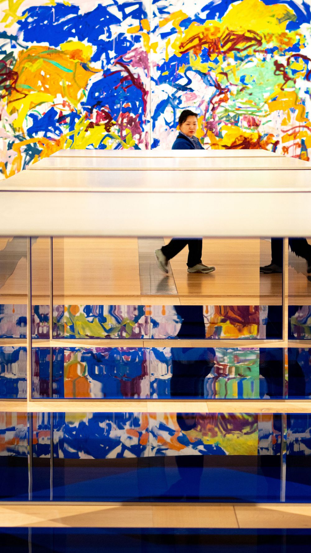 Vibrant abstract mural with blue and yellow colors creates dynamic backdrop in modern interior space.