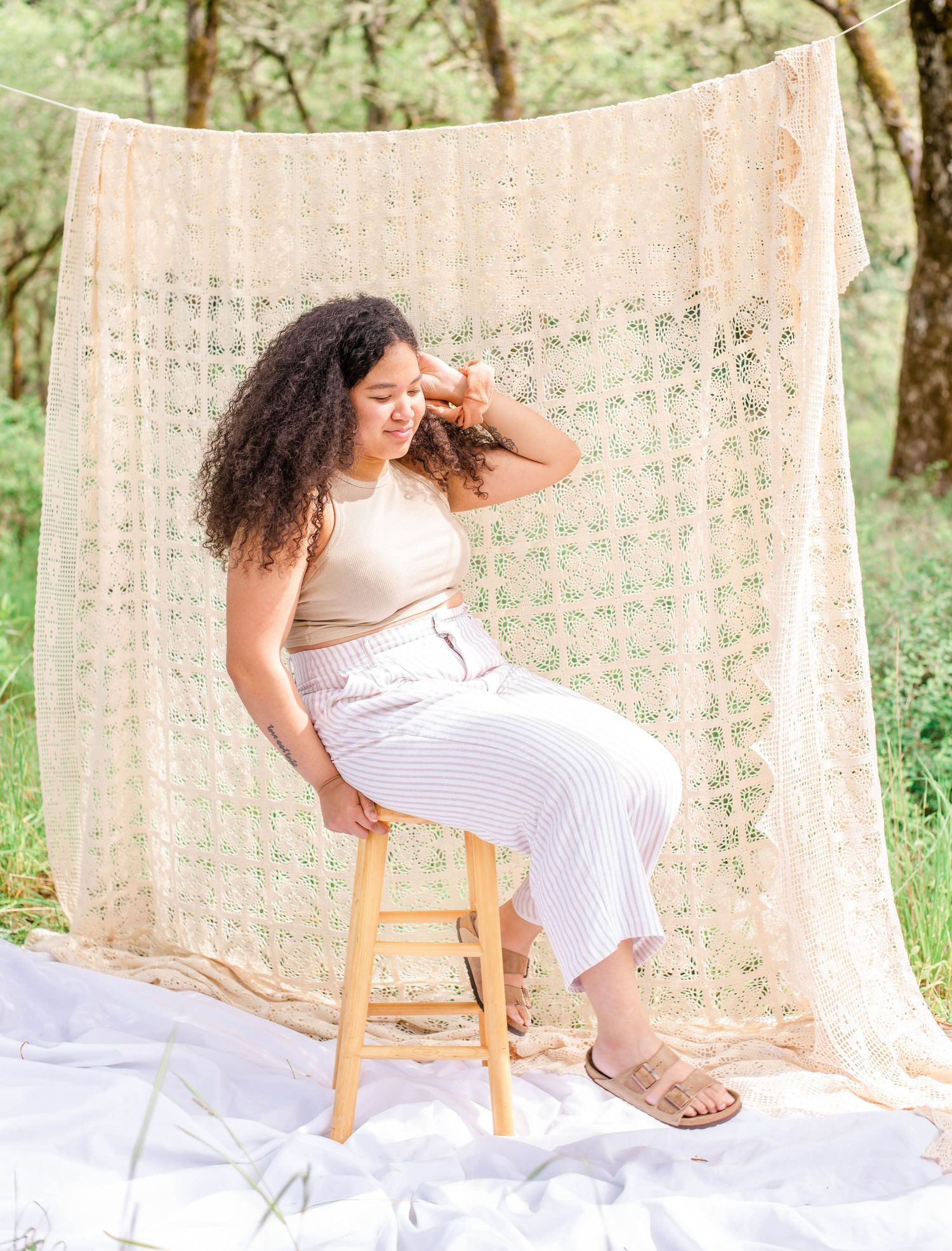 Lifestyle portrait setup with delicate lace backdrop and wooden chair in natural lighting.