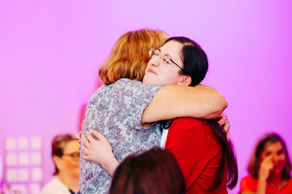 Emotional moments shared between attendees during a pink-themed celebration event.