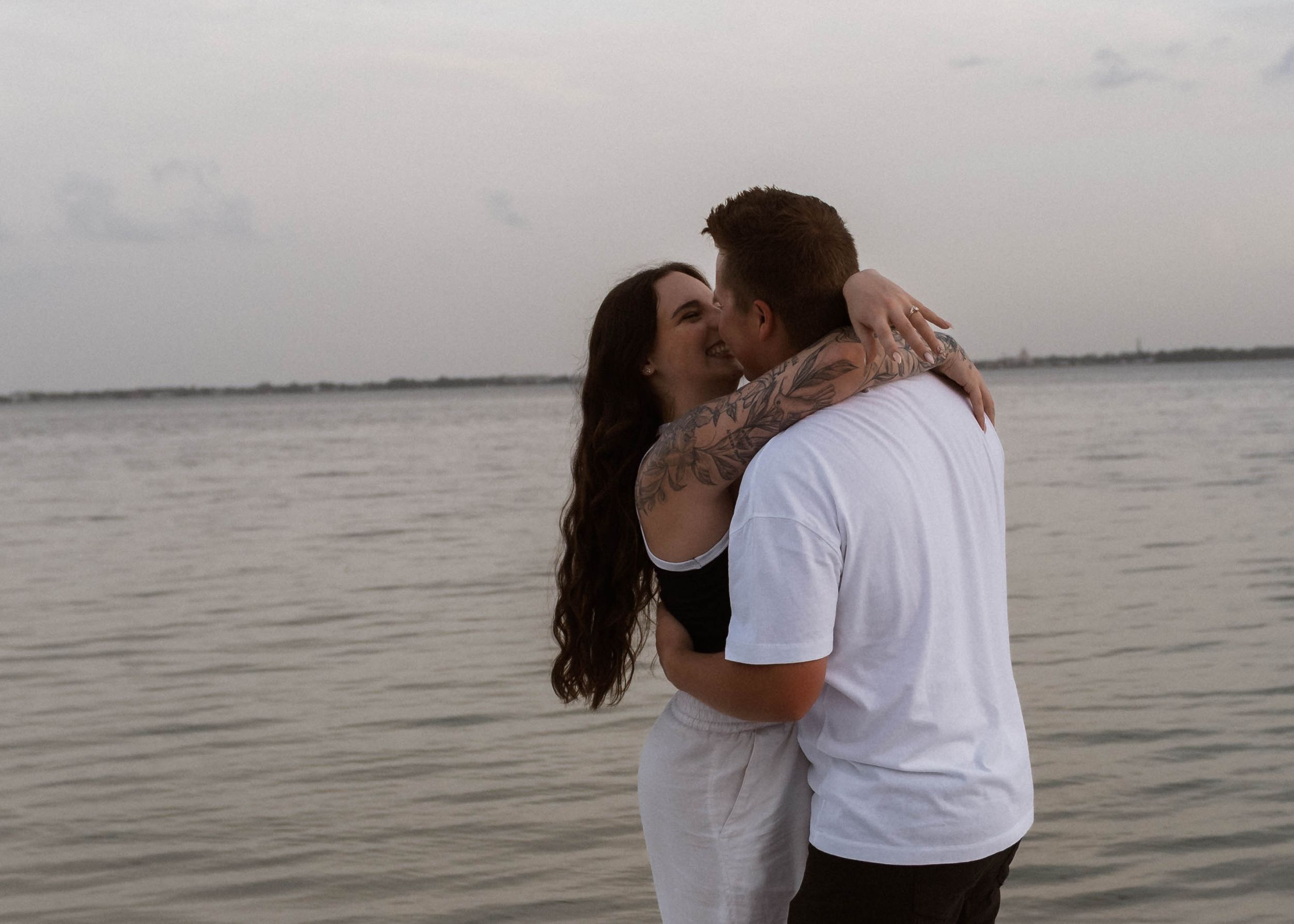 Couple laughing lakeside in Lakeland, Florida during a romantic portrait session by a Central Florida photographer.