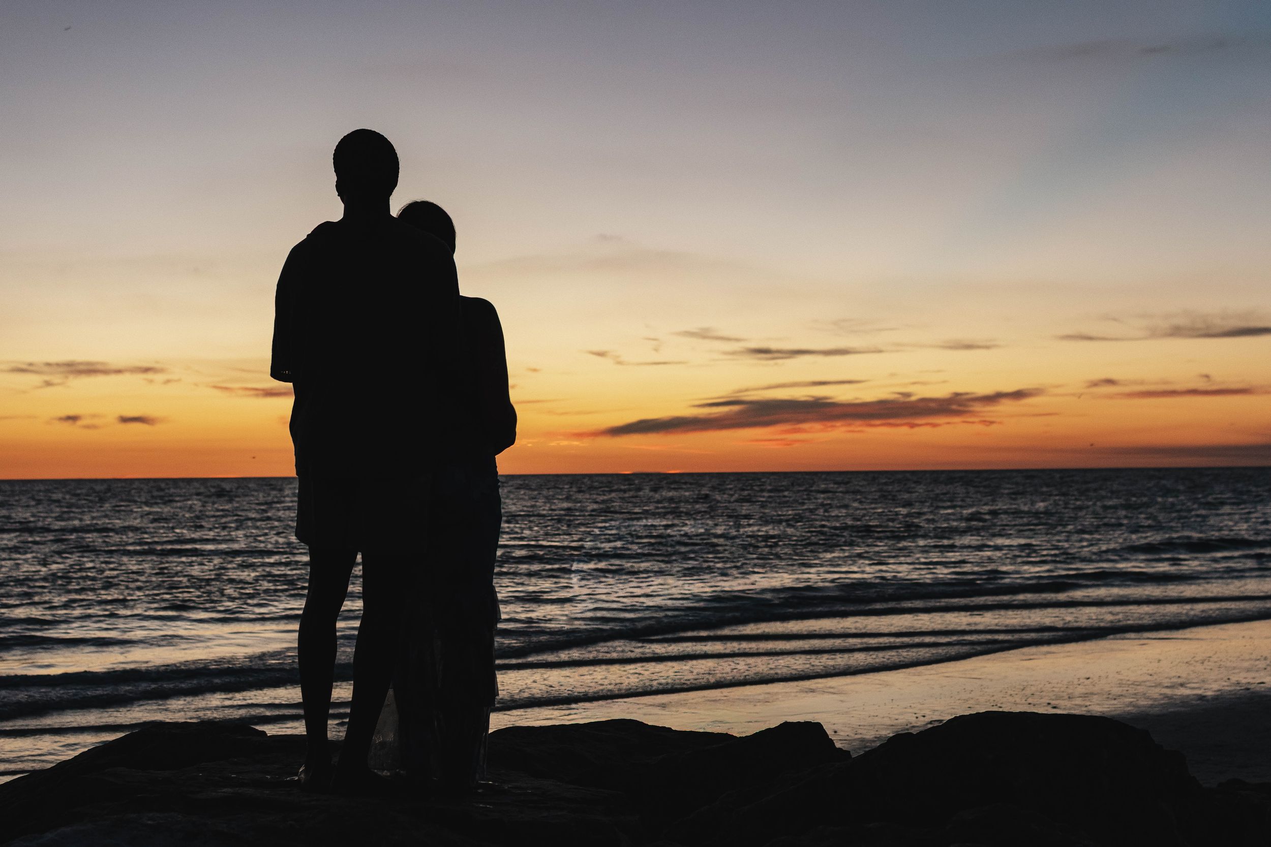 Silhouette of an engaged couple at sunset on St. Petersburg Beach, Florida by a proposal photographer.
